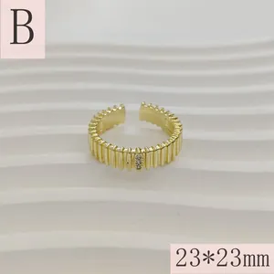 Gedetailleerd macroshot van een goudkleurige geribbelde open ring met kleine steentjes