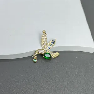 Detailansicht eines exquisiten Kolibri-Anhängers mit grünen Zirkonia-Steinen und Vergoldung