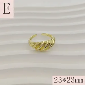 Detailopname van een goudkleurige gedraaide croissantring met een open achterkant