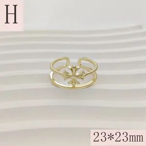 Detailopname van een gouden ring met kruismotief en afmetingen van 23*23mm groot