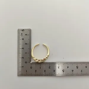 Detailweergave van een vergulde open ring met maatvoering op een liniaal