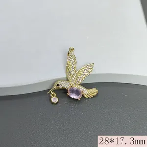 Detailaufnahme eines goldenen Kolibri-Anhängers mit rosa Steinen und Zirkonia-Inlay.