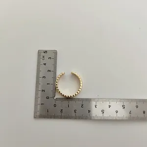 Gedetailleerd overzicht van verstelbare gouden kroonring met liniaal voor de maat