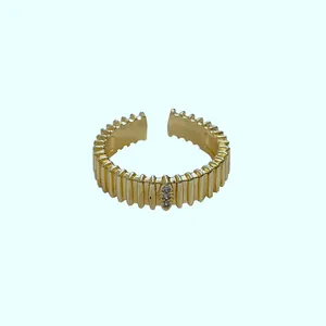 Elegante gouden open ring met geribbelde textuur en sprankelende steentjes