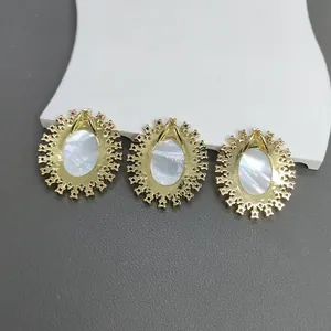 Nahaufnahme goldfarbener Retro-Anhänger mit Inlays aus natürlichem Perlmutt-Muscheln