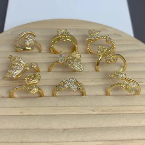 Vista dettagliata di anelli a farfalla placcati oro con brillanti accenti di zirconi.