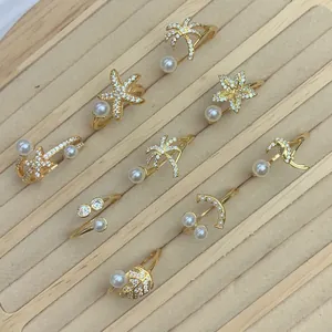 Detailansicht der vergoldeten verstellbaren Ringe mit Mikro-Zirkonia und Perlen.