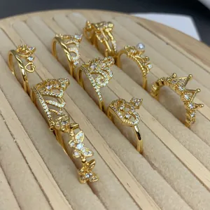 Varietà di anelli a corona e farfalla in oro con zirconi su un vassoio da esposizione.