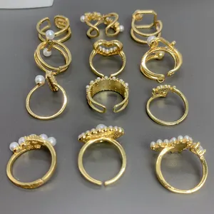 Colección de varios anillos de moda dorados con perlas y circonitas brillantes