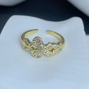 Dettaglio ravvicinato di un anello a farfalla placcato oro con pietre di zircone