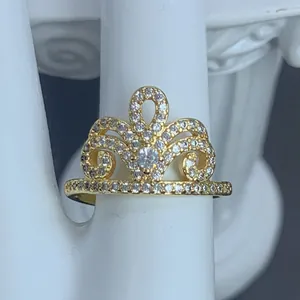 Vista dettagliata di un elegante anello a corona dorato con zirconi chiari scintillanti