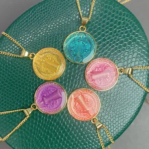 Primer plano de coloridos colgantes medalla San Benito con cadenas doradas