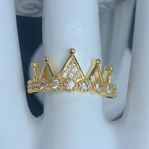 Vista dettagliata di un elegante anello a corona dorato con pietre di zircone lucenti.