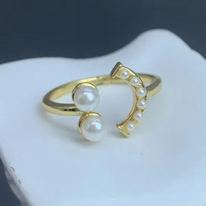Detailansicht der glänzenden Perlen und des goldenen Finishs dieses eleganten offenen Rings.