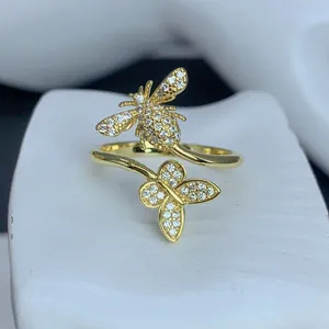 Primo piano di un anello aperto placcato oro con ape, farfalla e pietre di zircone