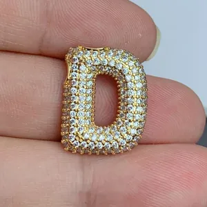Gros plan d'un pendentif lettre D plaqué or serti de zircons cubiques étincelants