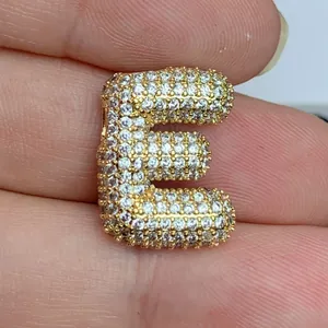 Détail d'un pendentif lettre E doré style bubble serti de pierres de zircone cubique