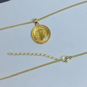 Detalle del collar con medalla de San Benito en oro y decoración de resina amarilla incrustada