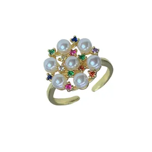 Elegante anillo abierto dorado con perlas blancas y diseño de flor de circón multicolor.