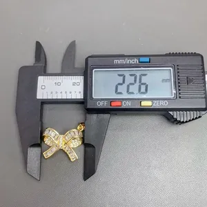 Παχύμετρο που μετρά το πλάτος 22,6 mm ενός χρυσού μενταγιόν φιόγκος με ζιργκόν