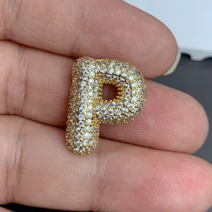 Détail macro d'un pendentif lettre P doré orné de pierres de zircone cubique brillantes