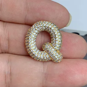 Gros plan détaillé d'un pendentif lettre Q doré serti de zircons cubiques scintillants
