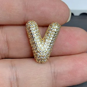 Détail macro du pendentif lettre V doré serti de pavé pour création de bijoux DIY
