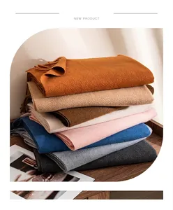 Close-up view of premium wool blend scarves in various colors with elegant fringe detail
