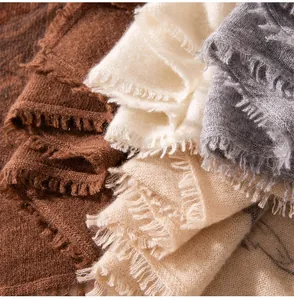 Primo piano di sciarpe in maglia di cashmere con frange delicate e stampe eleganti.