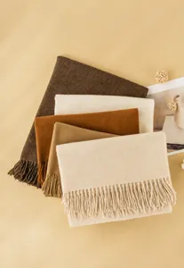 Detalle de bufandas suaves de imitación de cachemira lisas con flecos en tonos cálidos.