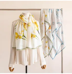 Elegant mulberry silk scarves with floral prints displayed on a mannequin and rack