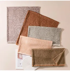 Detailed view of jacquard thistle pattern cashmere scarves in multiple earth tones