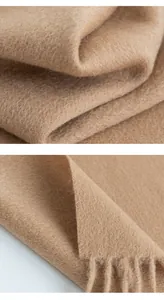Close-up of premium soft camel wool scarf showing fabric texture and tassel details