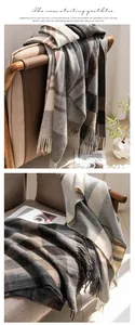 Detailed view of a soft gray plaid scarf draped on a brown chair in warm natural light
