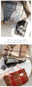 Detailed view of stacked classic plaid scarves in various warm and neutral tones