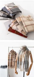 Classic plaid pattern winter scarves displayed on a wooden mannequin and stacked for detail