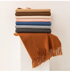 Macro view of stacked colorful wool blend scarves with elegant long fringe tassels