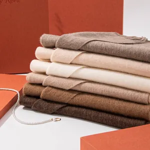 Detailed close-up showing the soft texture of stacked neutral wool earth-tone scarves