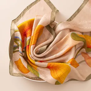 Elegant mulberry silk scarf with vibrant floral prints on a neutral beige background