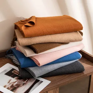 Cozy stacked wool scarves in various colors with fringe detail for autumn winter