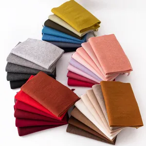 Stack of multi-colored solid wool scarves with fringe for autumn and winter collection