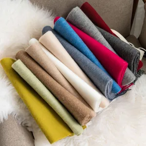 Stacked soft solid color wool scarves in various vibrant shades for winter warmth