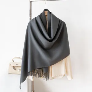 Detailed macro view of a dark grey solid color long scarf with elegant fringed tassels