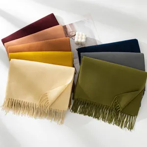 Macro view of various solid color scarves with thick tassels for extra winter warmth.