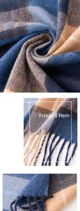 Close-up detail of soft plaid scarf fabric and elegant fringe tassels in blue and beige