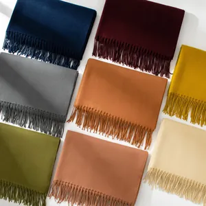 Assorted solid color winter scarves with elegant tassels showing fabric texture and color range