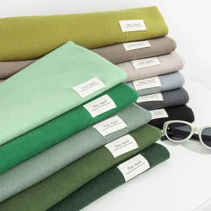 Soft Morandi green imitation cashmere scarves stacked with minimalist Day April labels
