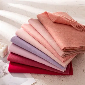 Stapel bunte Wollschals für den Winter in Rosa, Rot und Lila mit eleganten Fransen