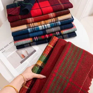 Close-up of multicolored plaid scarves with classic Christmas patterns and soft texture.