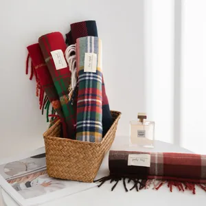 Detailed view of assorted colorful plaid scarves with soft tassels in a woven basket